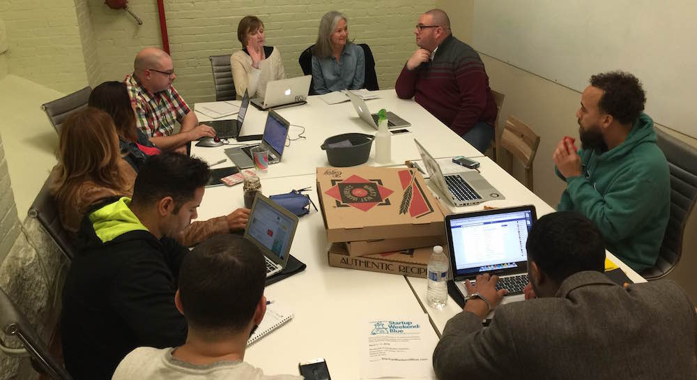 a group of people using the meeting room at Groundwork with pizza boxes