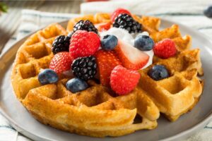 a waffle with berries and whipped cream